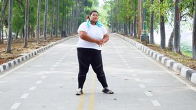 Happy fat woman wearing sportswear while stretching legs on the road. Shot in 4k resolution