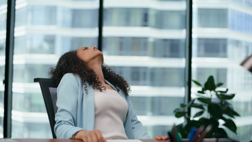 Unmotivated woman office worker tired of work sitting modern desk with papers close up. Upset exhausted girl touching head by hands feeling anxious. Latina businesswoman worried company problems. | Shutterstock HD Video #1095574605