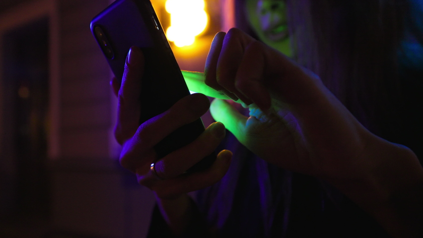 Focus on phone: Happy and cheering female crypto investor uses her smartphone to sell cryptocurrency