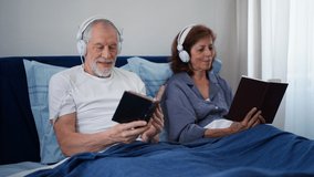 Happy senior couple reading books and listening music together in their bed. - Powered by Shutterstock - Get 15% off with code: PIKWIZARD15