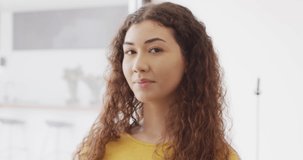 Video portrait of happy biracial woman smiling to camera indoors. Health, happiness, inclusivity and lifestyle concept.