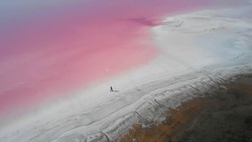 Girl walking on the Pink lake salt. Aerial video 4K with nature pink water lake of travel in the Pink lakes backgrounds. Ukraine