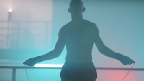 Boxer in the boxing gym. Bandages his hands. Sparring in the ring. Boxer jumping rope. Exercise with ropes. Round one. Fog in the ring. Zetsky sport. Beautiful backlight. World boxing champion.

 - Powered by Shutterstock - Get 15% off with code: PIKWIZARD15