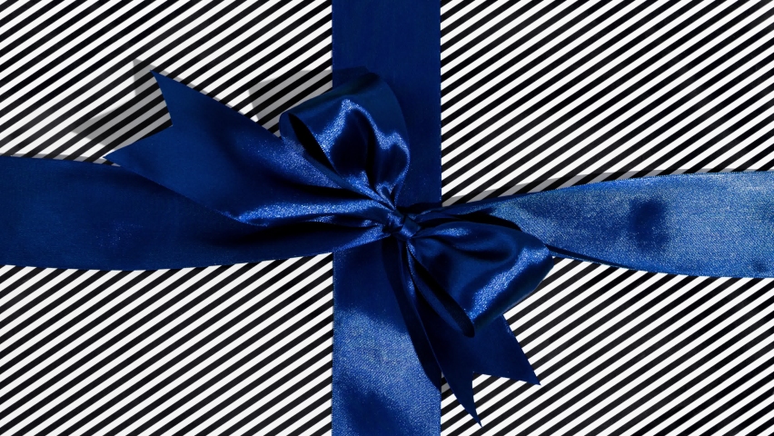 Unwrapping gift revealing a green screen - Stop Motion Animation - Blue ribbon with bow on a black and white background. Chroma key Royalty-Free Stock Footage #1095721419