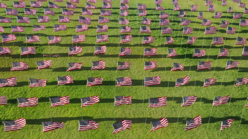 The Waves of Flags display at Alumni Park on the Malibu campus as seen from above. Aerial view of the ceremony commemorating lives lost in the September 11 terror attacks. High quality 4k footage Royalty-Free Stock Footage #1095749179
