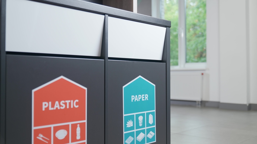 Waste recycle, separate garbage disposal, an office worker throws cardboard into container for paper waste and plastic into container for a plastic. | Shutterstock HD Video #1095760985