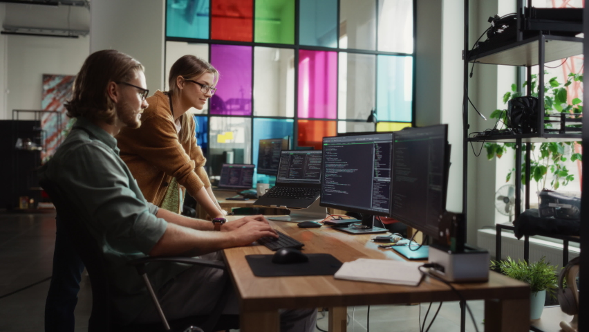 Male Data Scientist and Female Developer Working With Errors in Code on Desktop Computer in Creative Office. Caucasian Man and Woman Succesfully Fixed a Software Bug And High Five Each Other.