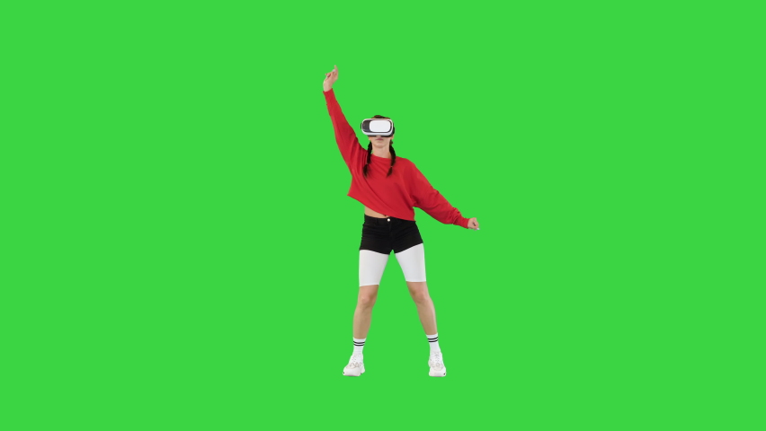 Young lady in sportswear and with VR-glasses making some robotic dance movements on a Green Screen, Chroma Key. | Shutterstock HD Video #1095766393