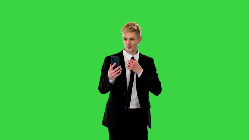 Confident young businessman walks, adjusts his tie and puts hands in his pockets on a Green Screen, Chroma Key. | Shutterstock HD Video #1095766403