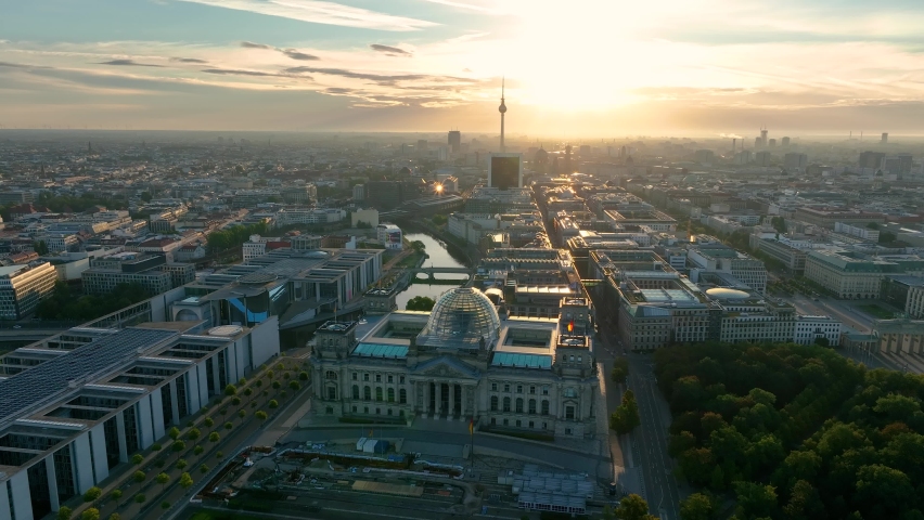 City of Berlin, Germany from above. Aerial cityscape view showing architectural landmarks Reichstag, TV Tower and Berlin Cathedral at sunrise. Drone flight to Alexanderplatz TV Tower, Sunflairs approx Royalty-Free Stock Footage #1095773205