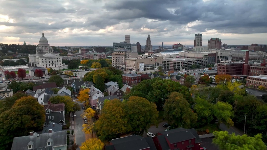 aerial over autumn colors on trees pushing toward the providence rhode island skyline