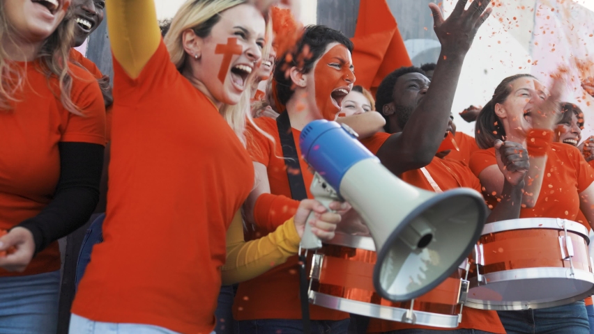 ORANGE sport football fans celebrating  team victory in championship game at stadium - Football supporters having fun in crowd