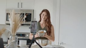 Vlogging female filming video in kitchen, baking pumpkin loaf