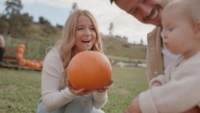 Close up of mom handing pumpkin to toddler, young family at pumpkin patch - Powered by Shutterstock - Get 15% off with code: PIKWIZARD15