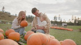 Young family at pumpkin patch, handing pumpkin to toddler - Powered by Shutterstock - Get 15% off with code: PIKWIZARD15