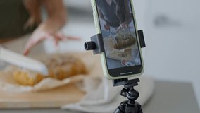 Close up of phone filming girl baking in apartment kitchen