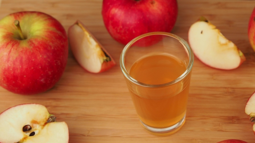 Apple cider vinegar is rotating on a wooden table. Royalty-Free Stock Footage #1095794445
