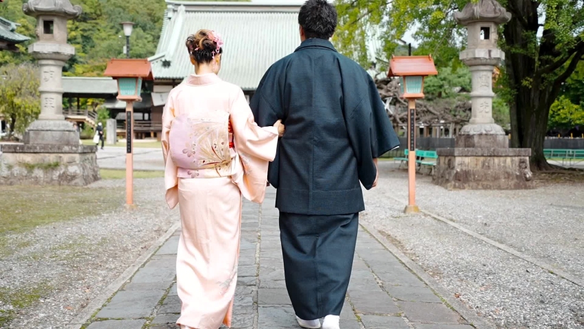Men and women in their 20s walking around a shrine in kimono