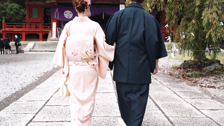 Men and women in their 20s walking around a shrine in kimono