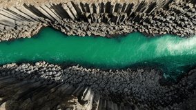 top down view aerial shot drone of scenic icelandic canyon studlagil,river flows into basaltic rock formation,iceland nature