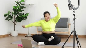 Fat woman blogger athlete in sportswear exercise in the room Publish content online on social media platforms. sports concept Exercise and healthy health care.