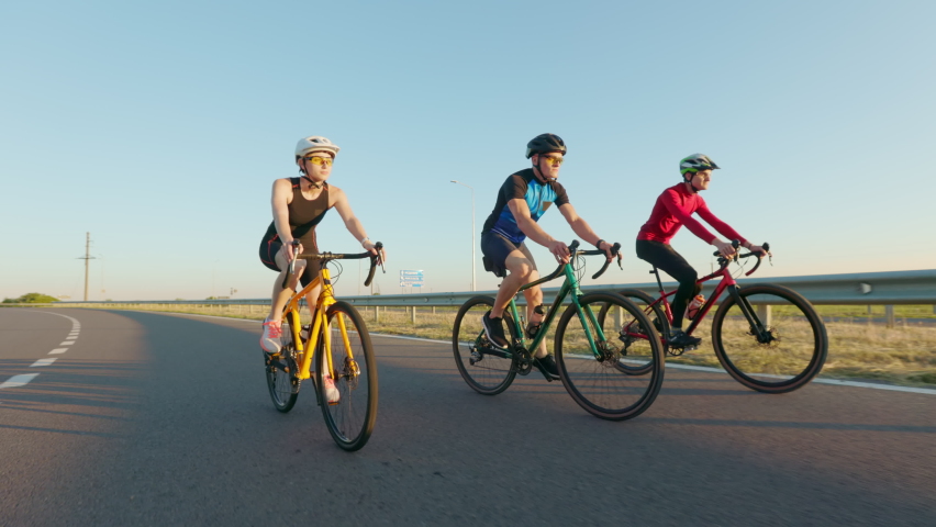 Sport people in activewear and helmets using professional bikes for cycling on fresh air. Caucasian men and woman enjoying active time spending outdoors.