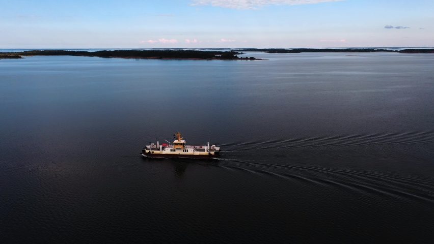 Aerial view following a ferryboat moving towards a island in Ahvenanmaa, Finland - circling, drone shot