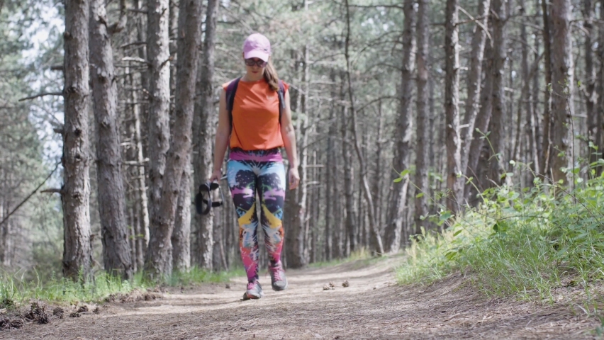 Girl hiking in a forest. Front view tying shoe lace.