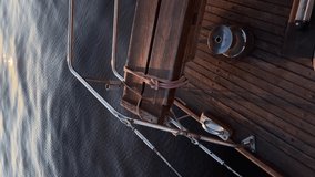 sunset on a sailing yacht. reflection in water. Wooden teak.
Vertical video