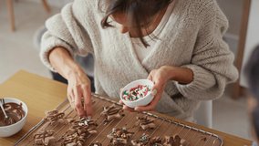 High angle view of multi ethnicity couple decorating sweet cookies with colorful sprinkles during the Christmas. Shot with RED helium camera in 8K. 