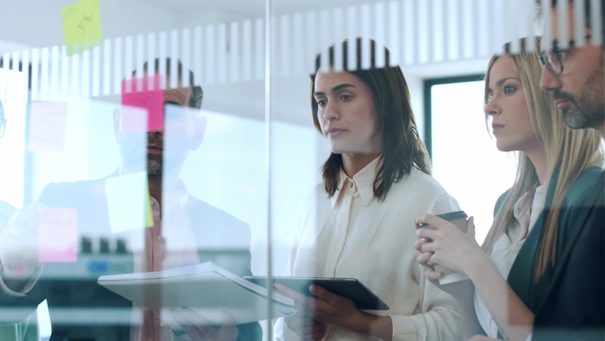 Video of successful business team writing on stickers at office glass board while discussing together in a modern startup Royalty-Free Stock Footage #1095814961