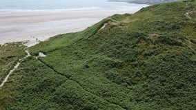 The slope of the green hill. Inchydoney beach, drone video, landscape. Beautiful seashore, view from above.