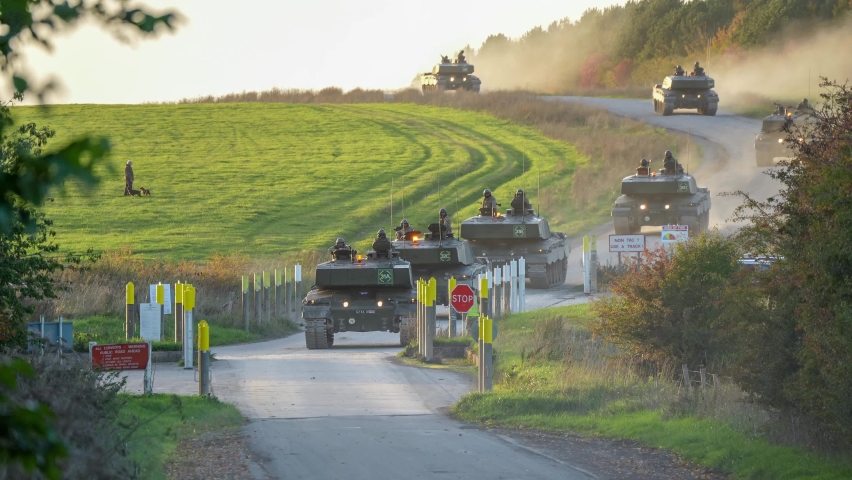 two sections of British army FV4034 Challenger 2 ii main battle tanks arriving at a road junction for supervised crossing
