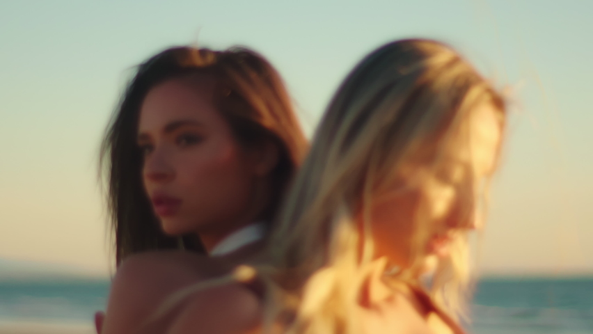 Portrait of two beautiful girls at sunset on the ocean. Blonde and brunette together Royalty-Free Stock Footage #1095831667