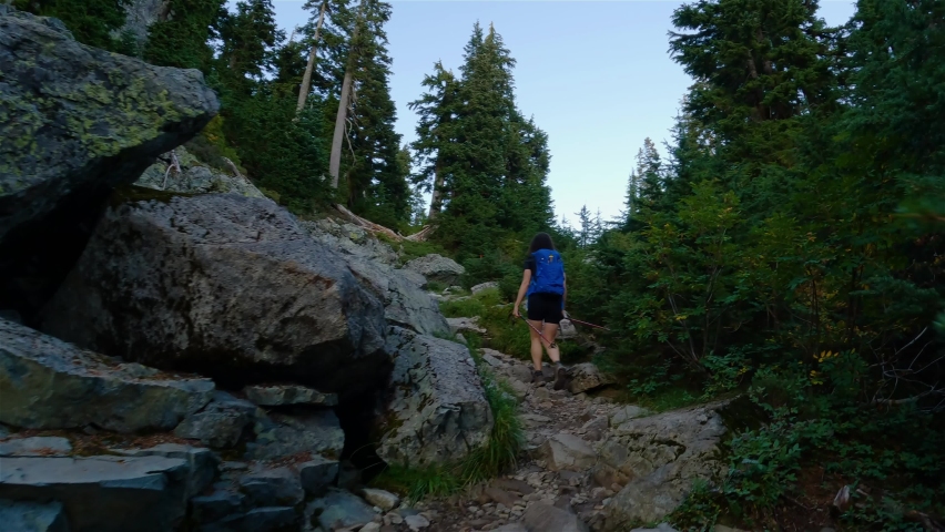 Adventurous Woman Hiker hiking on top of Canadian Mountain Landscape. Sunny Evening before Sunset. Top of Mt Seymour near Vancouver, British Columbia, Canada. Adventure Travel Concept