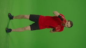 Vertical Video,Vertical View.Young Motivated Bearded Man Making Boxing Exercises in Fighting Gloves Straight to the Camera on Green Screen,Chroma Key.Man Kickboxing,Sport and Healthy Lifestyle Concept - Powered by Shutterstock - Get 15% off with code: PIKWIZARD15