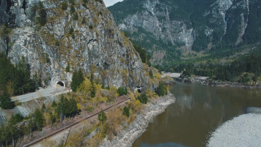Cars exit the tunnel on a Trans Canada Highway next to a railroad tracks. Fraser River, British Columbia