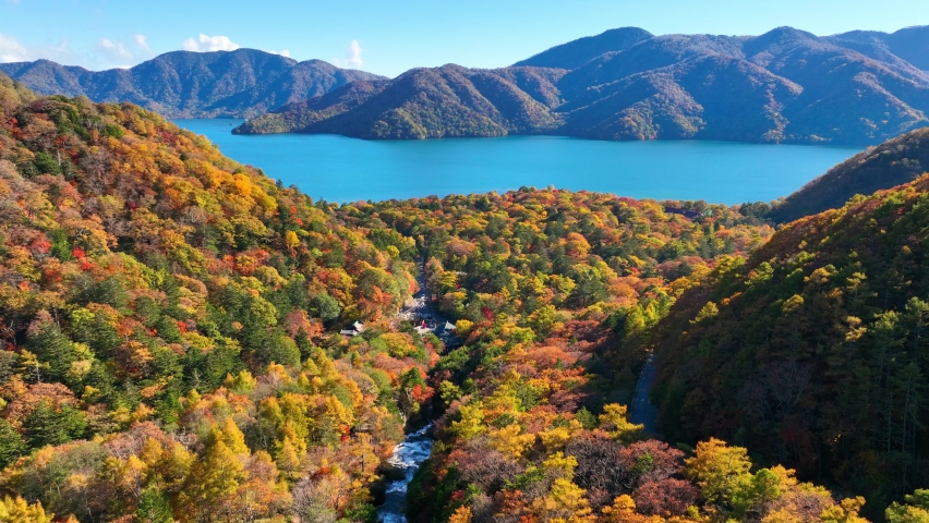 autumn at lake Chuzenji in Japan, aerial view of famous Japanese travel destination in Nikko national park, flying above autumn forest near blue lake. High quality 4k footage Royalty-Free Stock Footage #1095839215