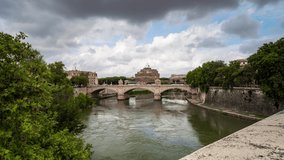 Time lapse video with moving clouds above medieval St. Angelo castle and Vittorio Emanuele II Bridge over Tiber river in Rome, Italy 