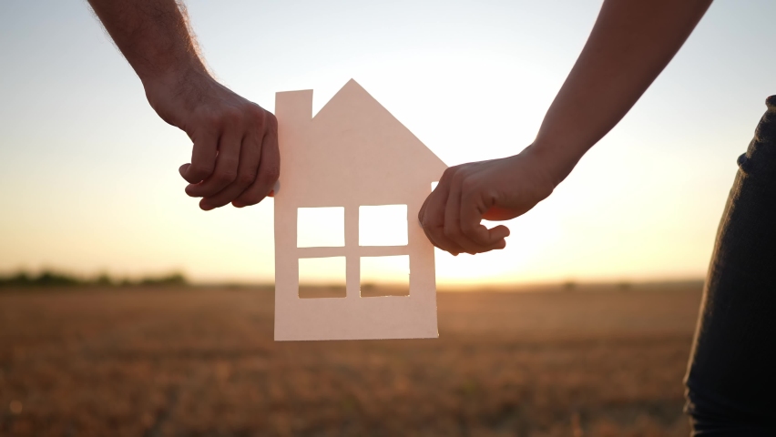 paper house happy family. friendly family hands holding paper house the glare of the sun shine through the window a beautiful sunset. mortgage lifestyle business construction concept. house dreams Royalty-Free Stock Footage #1095843329