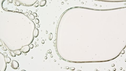 Transparent cosmetic gel fluid with molecule bubbles oil distribution on a white background. Macro Shot of Natural Organic Cosmetics, Medicine. Production Close-up. Slow Motion - Βίντεο στοκ