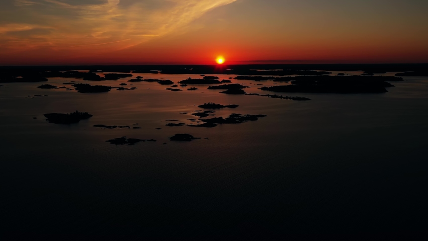 Aerial view approaching silhouette islands, summer sunset in Ekenas Archipelago national park, Finland