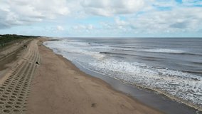 Aerial video footage of Seaside Waves Near A Sandy Beach Shore On A Beautiful Sunny Summer Day. Lincolnshire coast, Skegness, beach, long