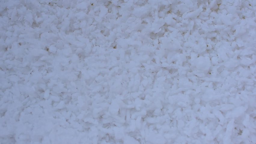 white polystyrene beads wind blowing yellow background with space for text