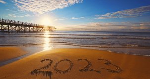 Happy New Year 2023 concept, lettering on the beach. Written text on the sea beach at sunrise.