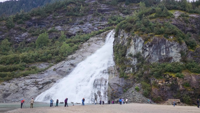 Nugget Falls near Mendenhall Glacier in Juneau Alaska with tourists taking pictures Royalty-Free Stock Footage #1095860857