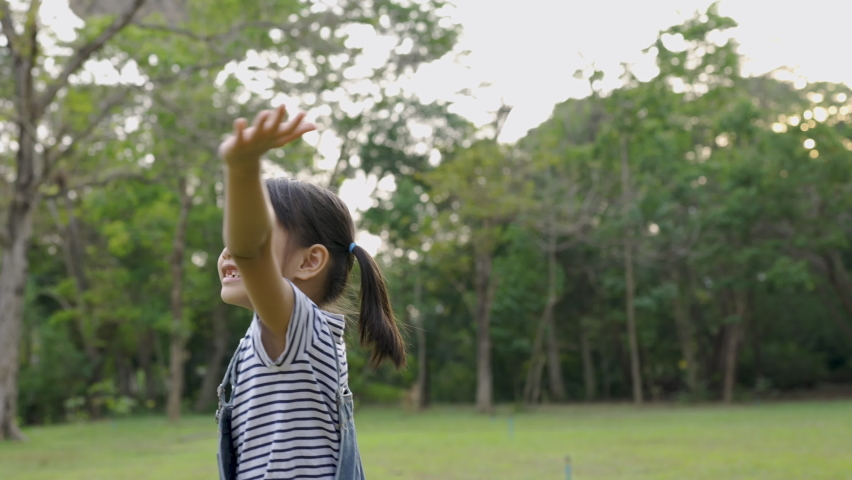Happy asian little toddler girl walking enjoying the life in the green grass rice paddy. Nature beauty, field of rice. Family outdoor lifestyle. Freedom concept. Cute little girl in summer green park