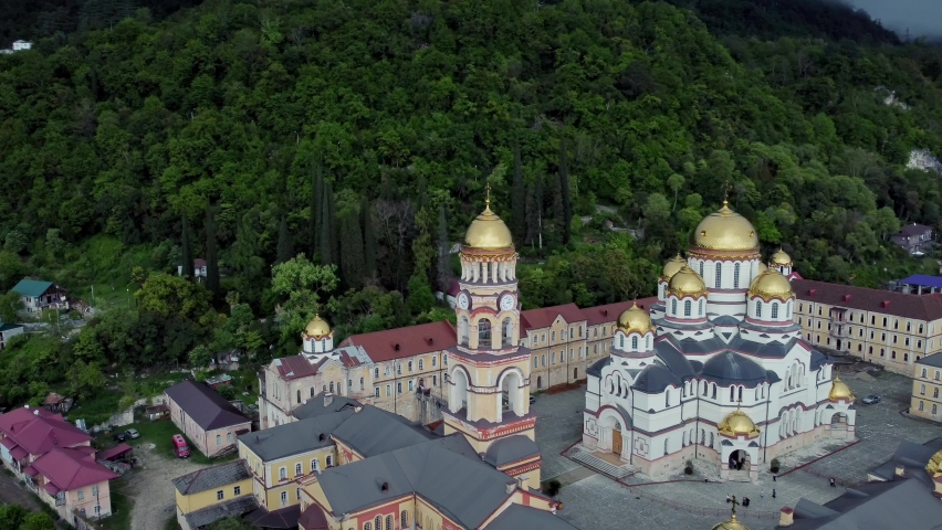 4k Top view of church and green mountain outdoors irrl. Aerial of Christian temple against backdrop of high rocks overgrown with vegetation in summer. Beautiful shot from flying drone of religious