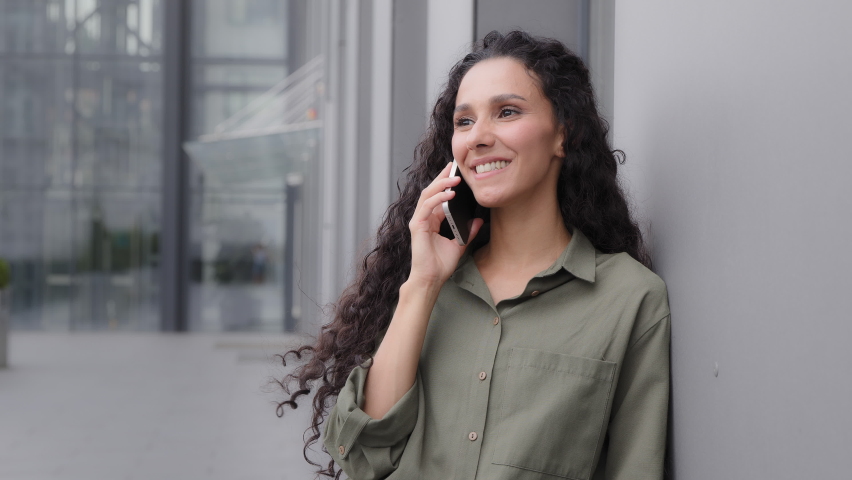Close up laughing smiling happy millennial woman in city outdoors has remote conversation by smartphone talking phone unexpected good news gossip win victory amazed surprised girl say wow answer call Royalty-Free Stock Footage #1095873845