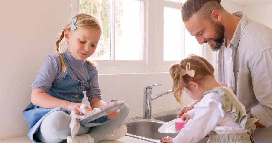 Family, father and girls washing dishes in kitchen helping with housework in house. Teamwork, support and man bonding with happy kids, cleaning plates and learning or teaching good hygiene in home. Royalty-Free Stock Footage #1095884557
